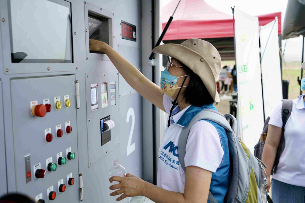 志工們將拾起的寶特瓶投入「好歸塑專車(chē)」，讓廢棄塑料空瓶可以直接粉碎、縮小體積，未來(lái)將可再製成購(gòu)物袋、寶特衣、悠遊卡等生活用品