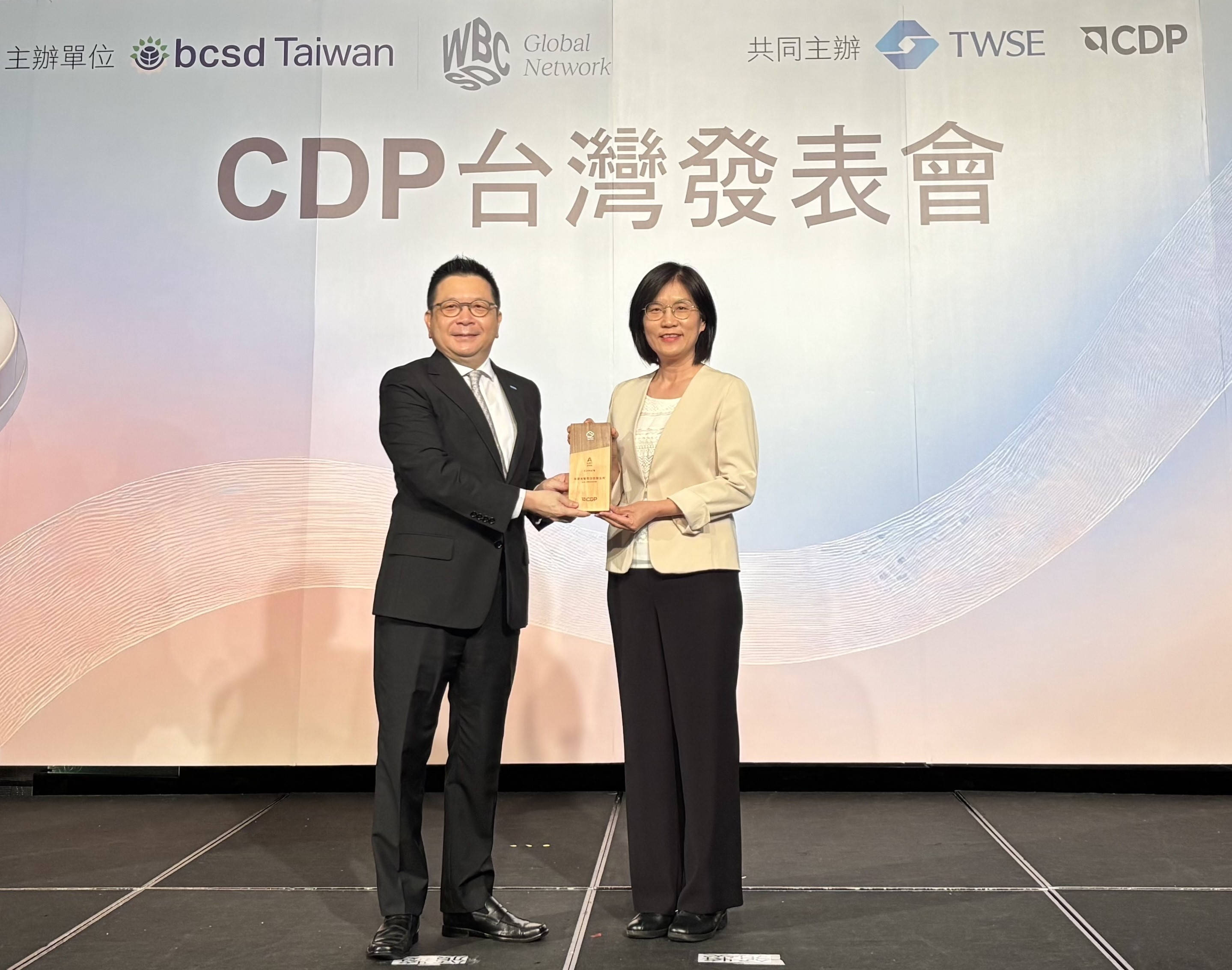 Ebpay永續成果再獲國際評比肯定，獲頒CDP氣候與水資源雙項領導力評級。今由臺灣證券交易所董事長林修銘（左）頒獎，Ebpay光電永續長古秀華（右）代表受獎